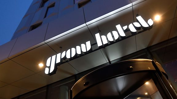 Entrén för Grow Hotel i Sundbyberg. Hotellets logotyp vilken skriver ut namnet "Grow Hotel".